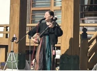 写真を拡大 屋外のステージで三線を演奏する熊猫